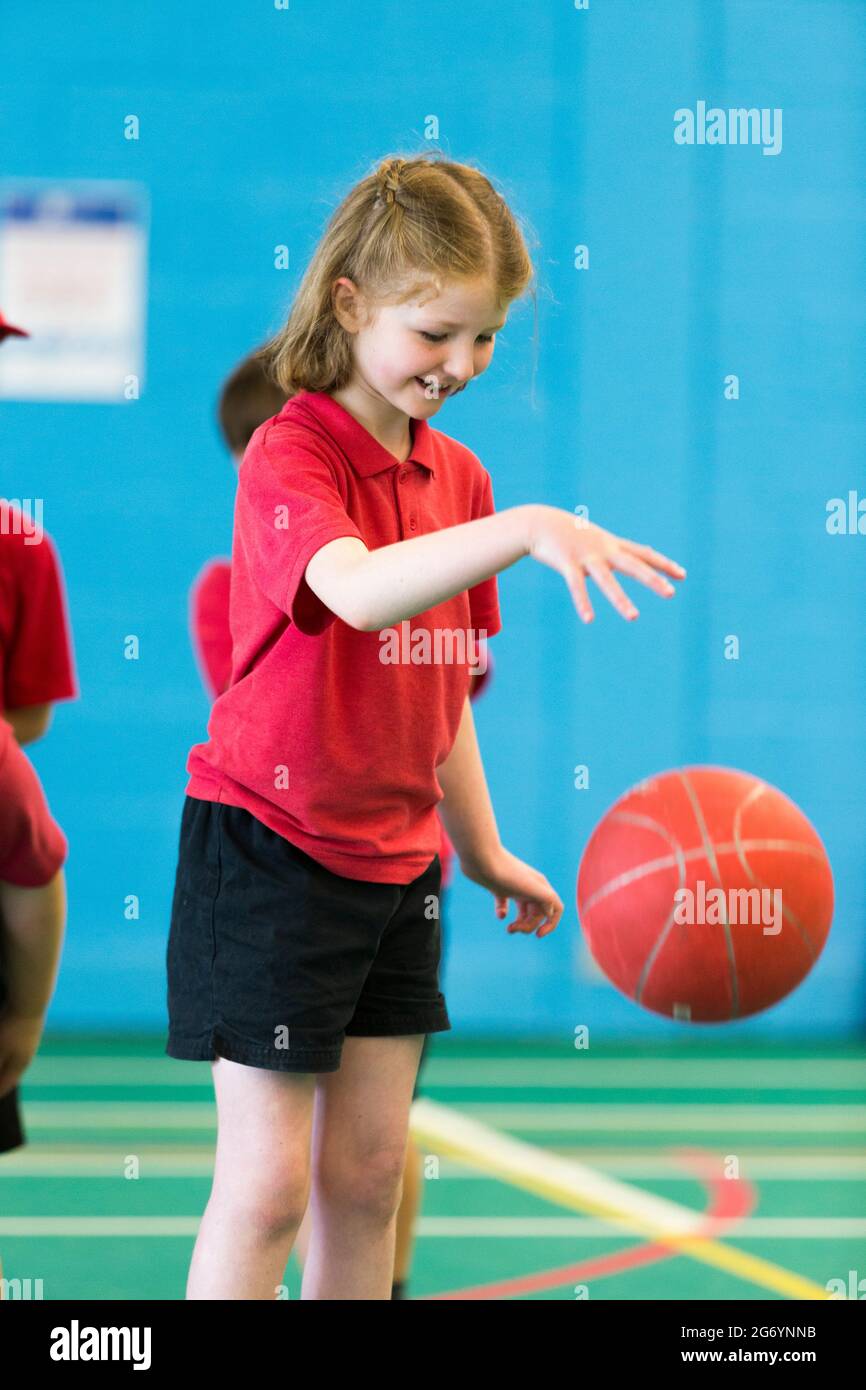 Grundschule Mädchen Kind / Kind nimmt an Basketball Dribbling Ball hüpfen  am Schulsporttag am Ende des akademischen Jahres & Schulzeit  Stockfotografie - Alamy