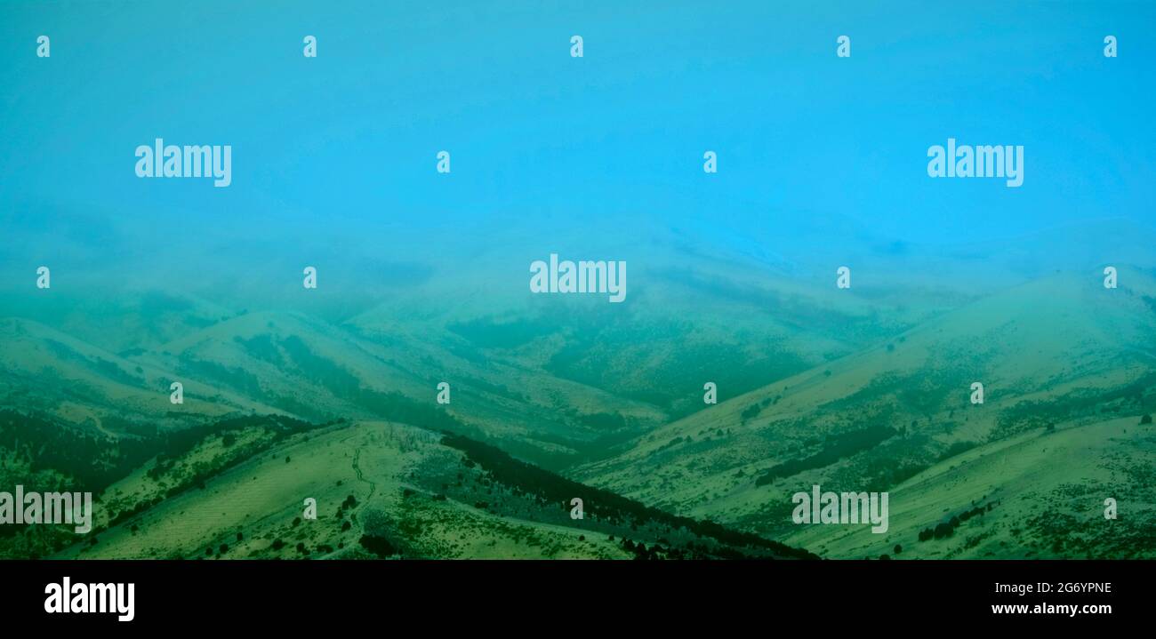 Berge mit frühmorgendem Nebel, orangefarbenem Himmel, Abenduntergang Stockfoto