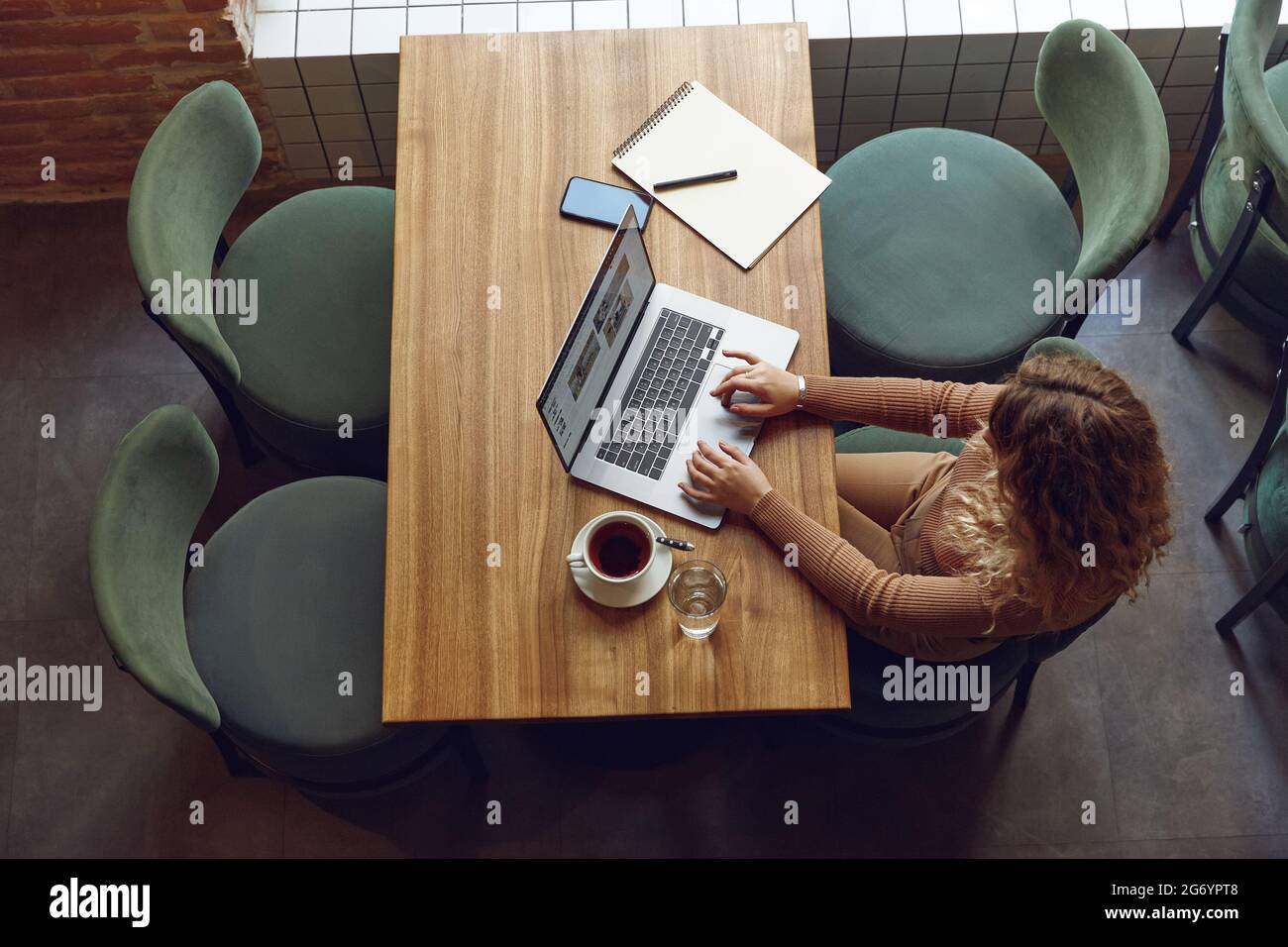 Frau, die im Café am Laptop arbeitet Stockfoto