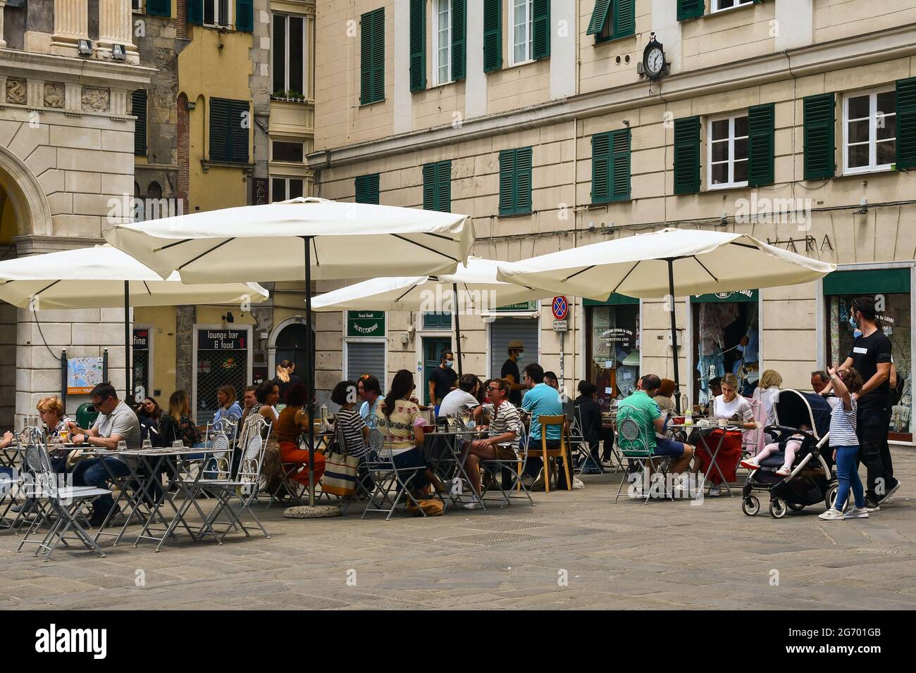 Menschen sitzen in einem Café-Restaurant im Freien auf dem Sankt-Lorenz-Platz, dem historischen Zentrum von Genua, im Sommer Ligurien, Italien Stockfoto