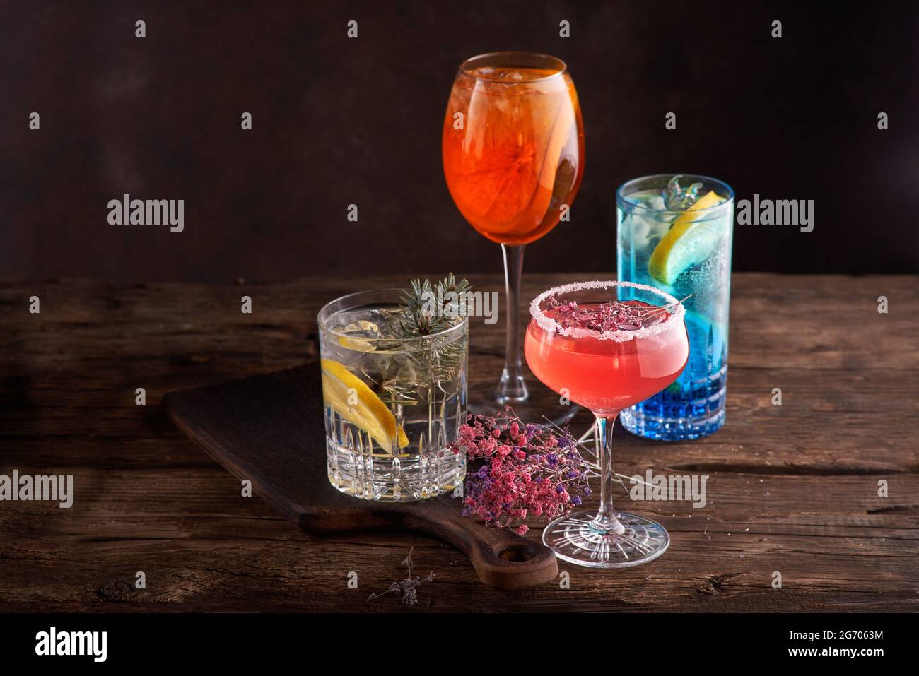 Verschiedene schöne Cocktails in warmen Farben auf dunklem Hintergrund. Stockfoto