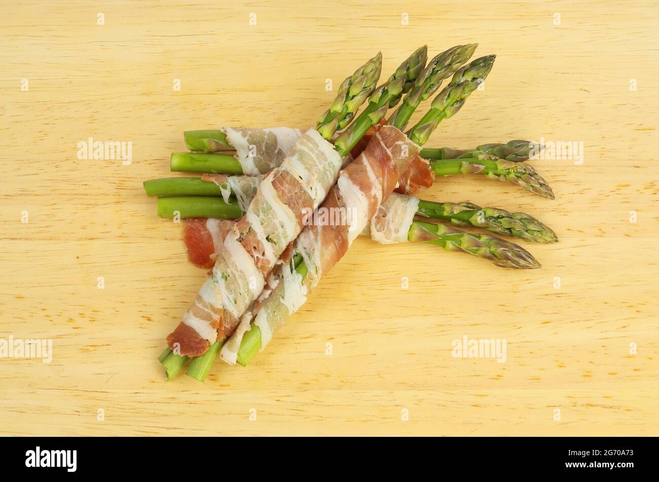 Spargel mit Pancetta auf einem Holzbrett gewickelt Stockfoto