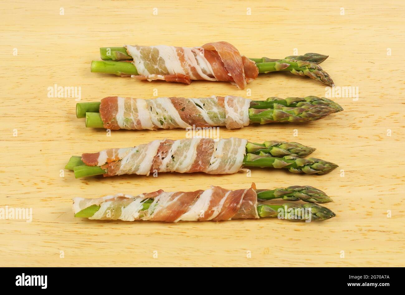Spargel mit Pancetta auf einem Holzbrett gewickelt Stockfoto