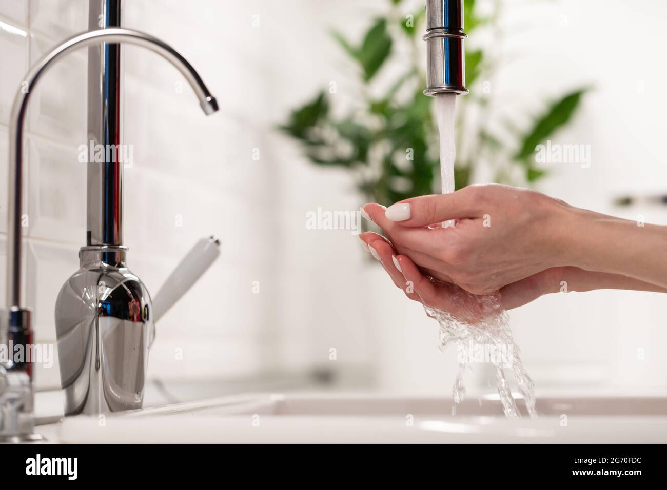 Frau, die sich im Waschbecken in der Küche oder im Badezimmer zuhause die Hände wascht. Sauberkeit, Hygiene und Gesundheitskonzept Stockfoto