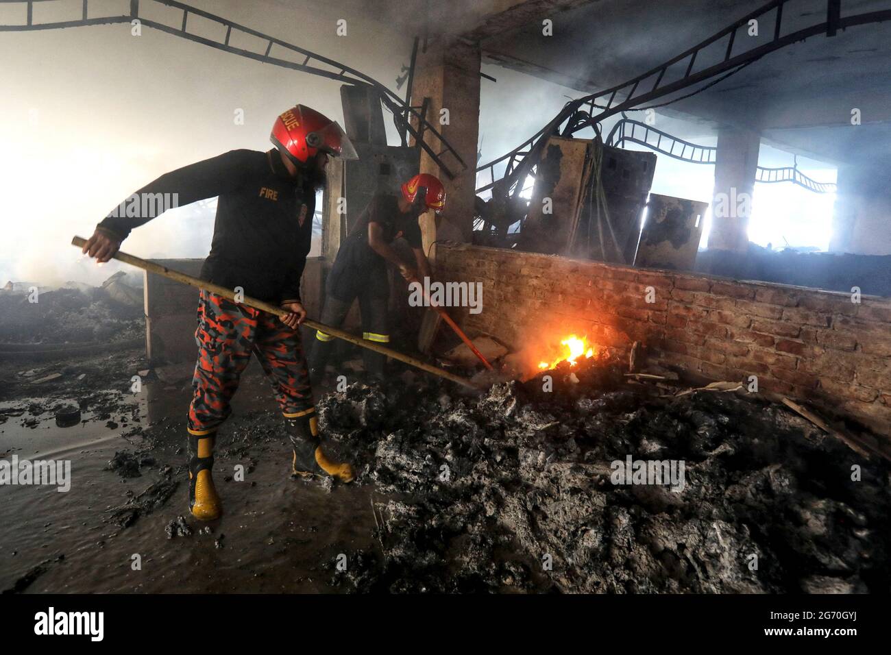 Narayanganj, Bangladesch. Juli 2021. (210709) -- NARAYANGANJ (BANGLADESCH), 9. Juli 2021 (Xinhua) -- Feuerwehrleute arbeiten am 9. Juli 2021 auf der Feuerstelle einer Saftfabrik in Narayanganj am Stadtrand von Dhaka, Bangladesch. Mindestens 52 Menschen sind gestorben, als ein riesiges Feuer einen zweiten Tag lang in der Saftfabrik in Narayanganj wütete. (Xinhua) Quelle: Xinhua/Alamy Live News Stockfoto