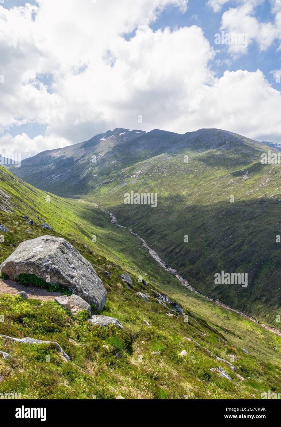 Uralte Felsen am Geröllhang über einem Flussbett Stockfoto