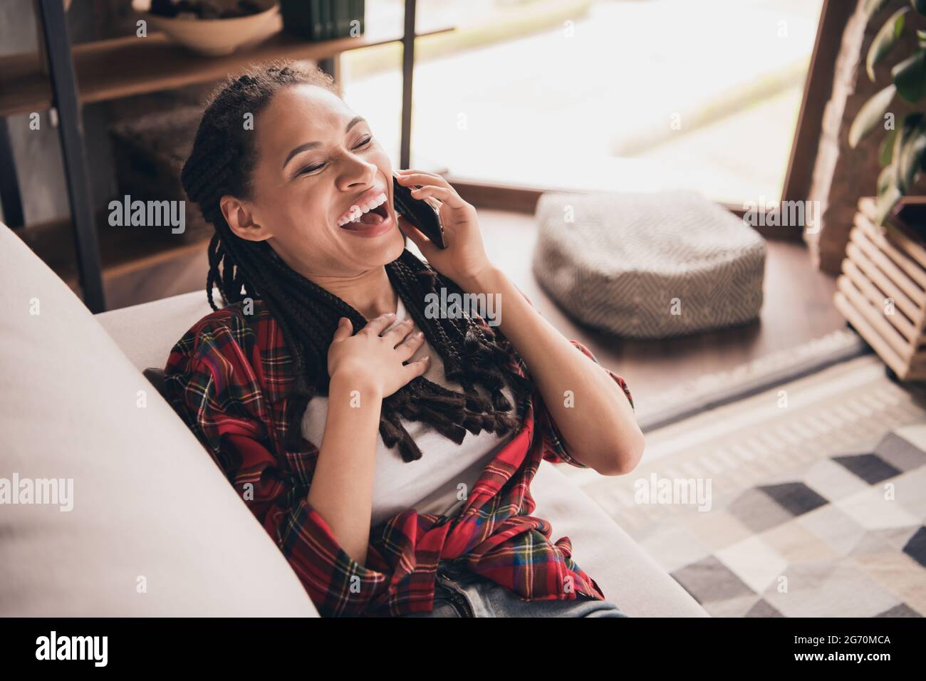 Portrait von attraktiven fröhlichen Mädchen auf dem Sofa sitzend Freund lachend urkomische Geschichte im modernen Loft industriellen Wohnung Haus drinnen Stockfoto