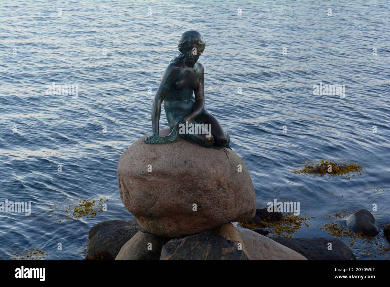 Kopenhagen, Dänemark - 2021. Juli: Die kleine Meerjungfrau-Statue (Den lille Havfrue), die auf einem Felsen am Wasser an der Langelinie-Promenade dargestellt ist Stockfoto