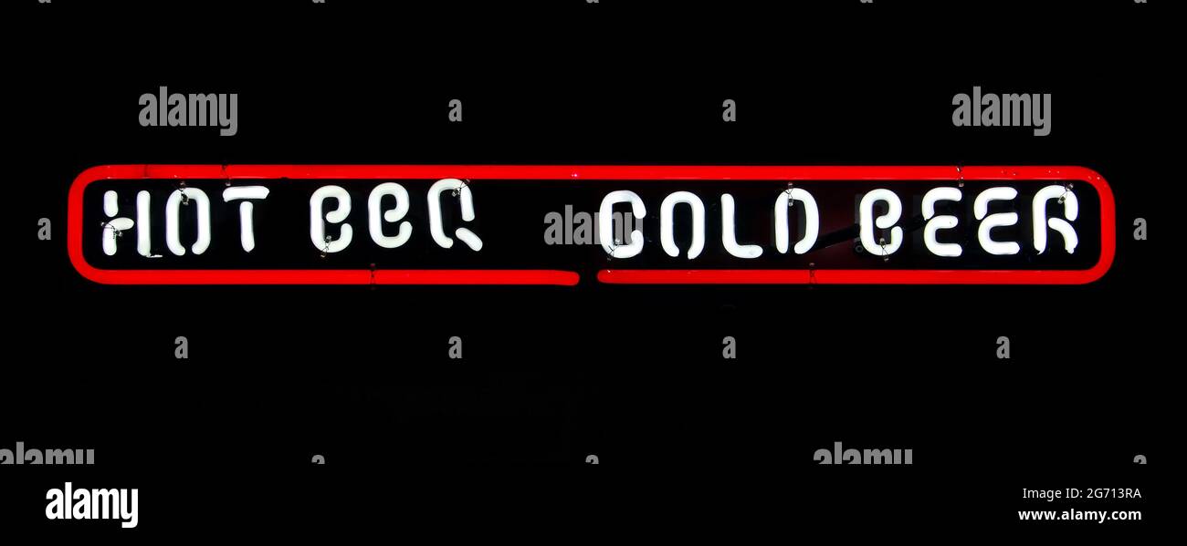 Leuchtendes weißes Schild mit der Aufschrift „Hot BBQ“ und „Cold Beer“ mit einem roten Umriss auf einem pechschwarzen Hintergrund Stockfoto