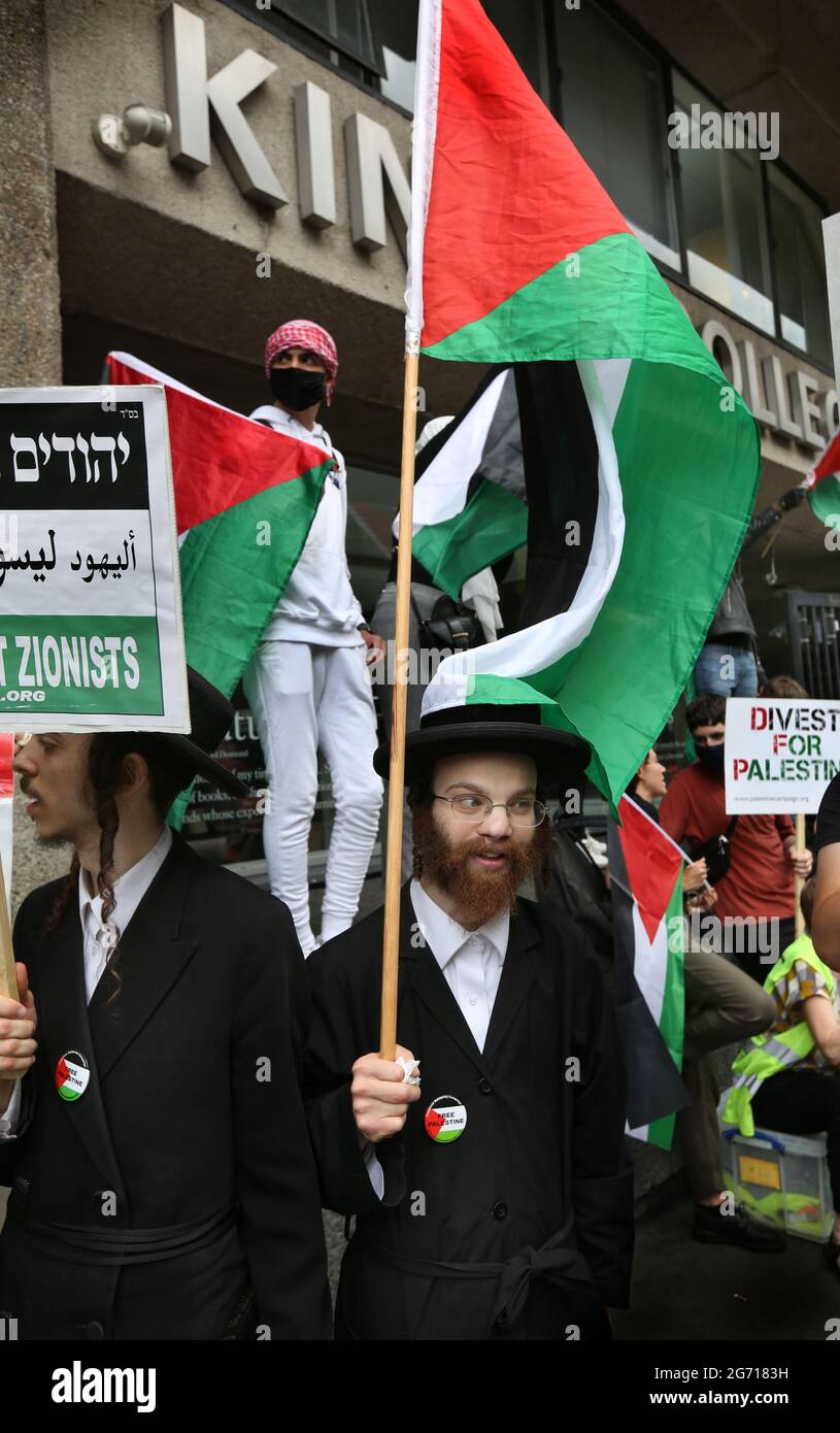 London, Großbritannien. Juli 2021. Protestierende der orthodoxen jüdischen antizionistischen Gruppe, der Neturei Karta, halten während eines Protestes palästinensische Fahnen und Plakate vor dem King's College.Studenten und andere Protestierende gehen auf eine Tour durch die Londoner Universitäten, um einen Boykott für alle israelischen akademischen und kulturellen Institutionen zu fordern, in Solidarität mit dem Kampf gegen die Beendigung der israelischen Universitäten Besetzung, Kolonisierung und Apartheid-System in Israel. (Foto von Martin Pope/ SOPA Images/Sipa USA) Quelle: SIPA USA/Alamy Live News Stockfoto