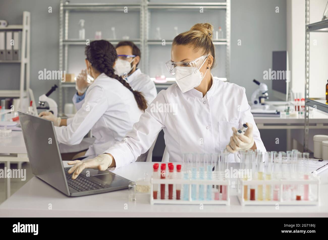 Wissenschaftler, die in einem medizinisch-wissenschaftlichen Labor forschen und an einem Laptop arbeiten Stockfoto