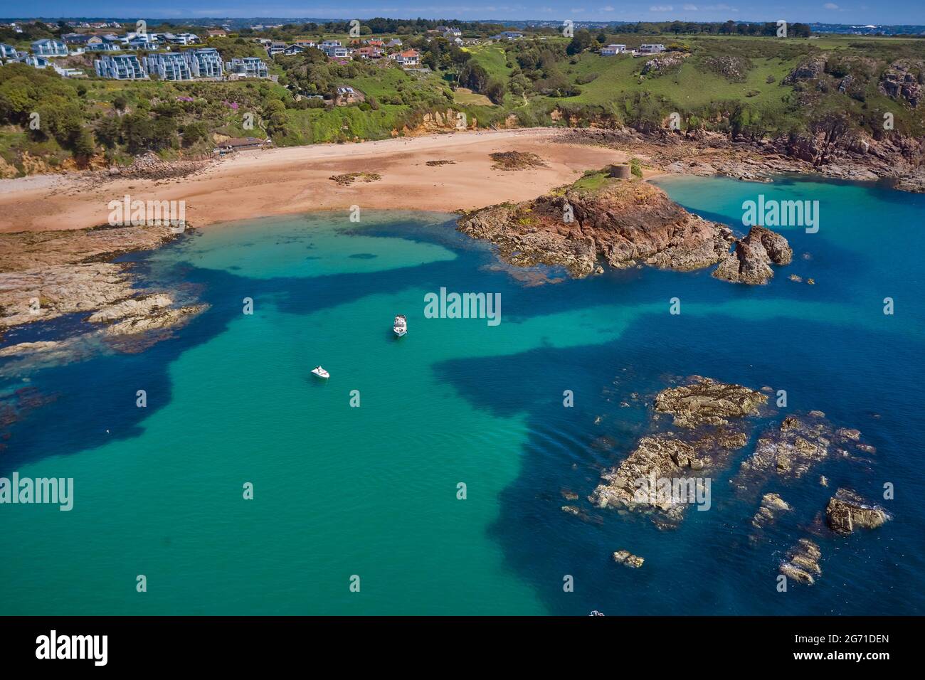 Luftdrohnenaufnahme der Portelet Bay, Jersey, Kanalinseln mit blauem Himmel und ruhigem Wasser. Stockfoto