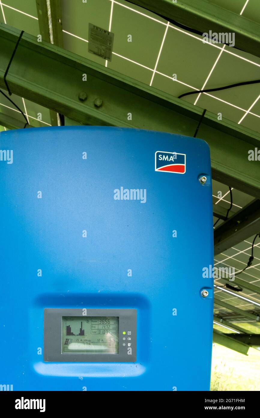 SMA Solar-Technologie-Wechselrichter unter einer Reihe von Outdoor-Solarmodulen, Großbritannien Stockfoto