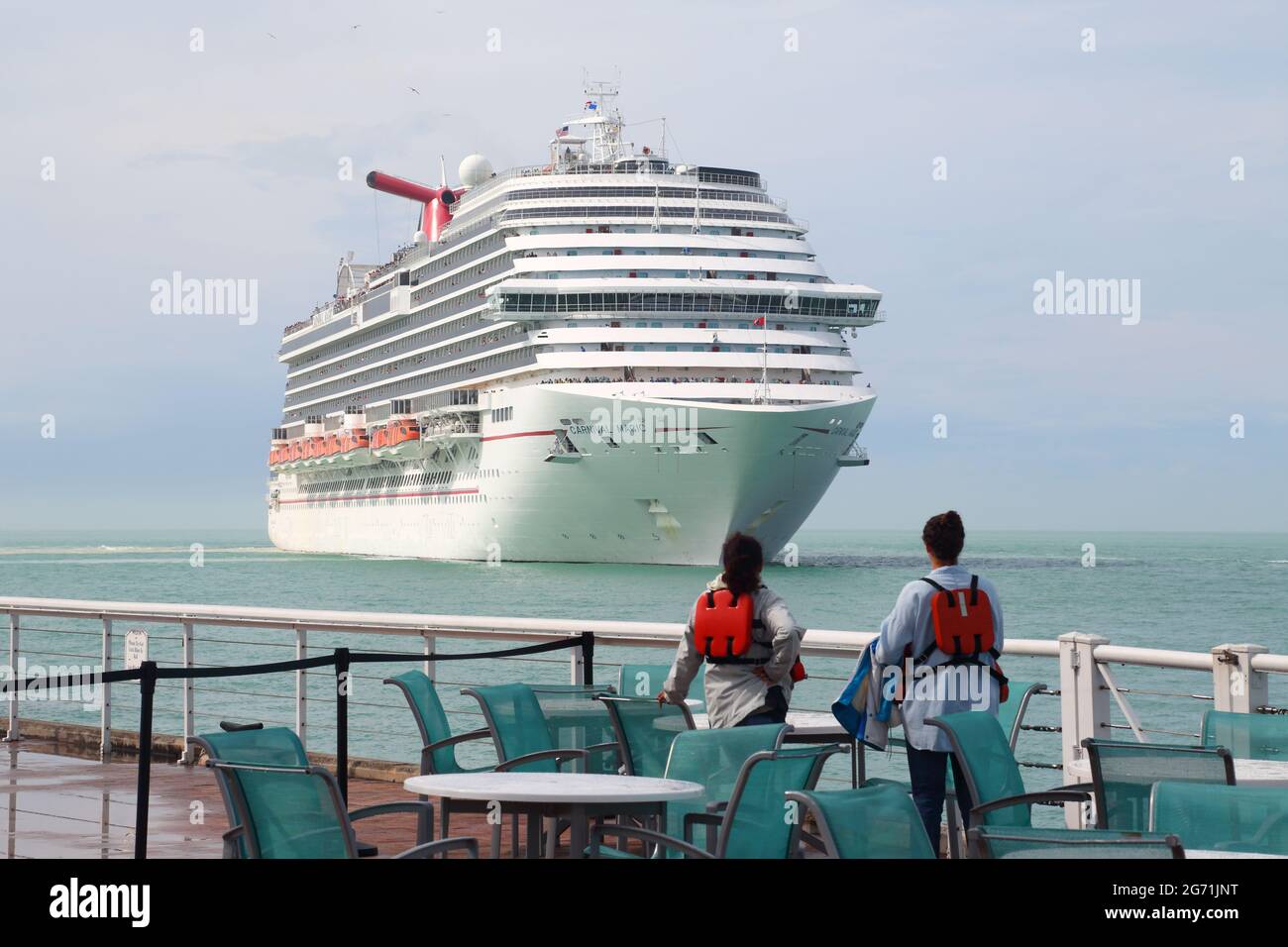 Zwei junge Frauen beobachten das Kreuzschiff Carnival Magic bei der Ankunft in Key West, Florida, USA Stockfoto