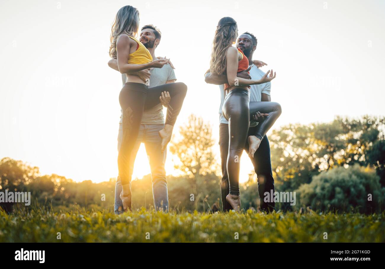 Zwei Paare tanzen fortgeschrittene Kizomba bewegt sich während Sonnenuntergang in einem Park Stockfoto