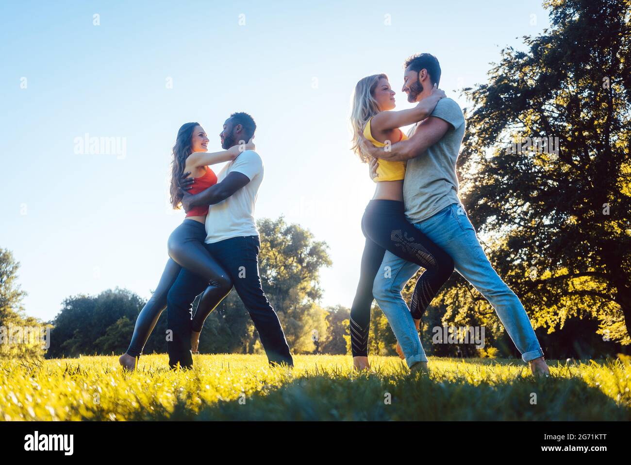 Frauen und Männern Spaß tanzen im Park als Paare Stockfoto