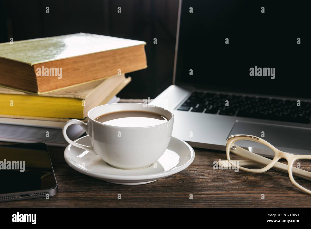 Tasse Kaffee und Laptop auf Holztisch Stockfoto