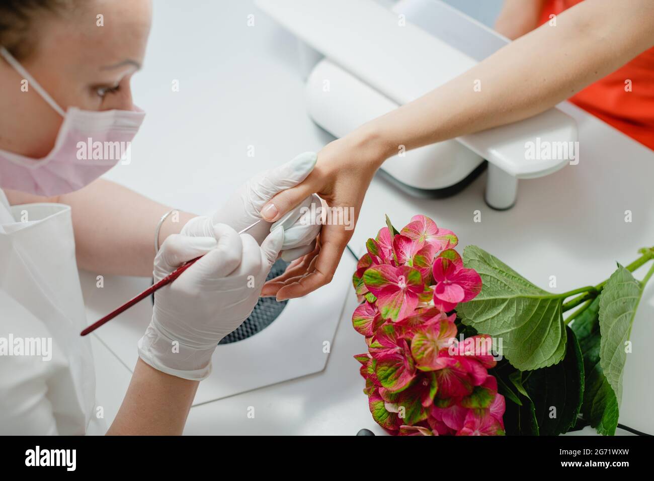 Nagelkünstlerin, die mit einer Klientin arbeitet, von oben gesehen Stockfoto