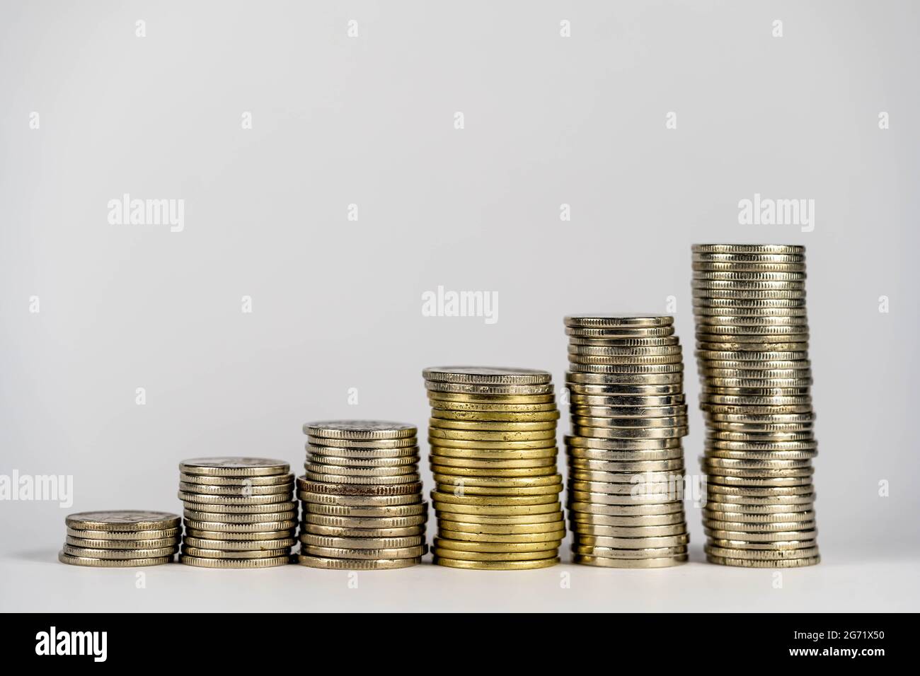 Legen Sie die Münzen in einer Linie von niedrig bis hoch. Verwalten Sie Ihre Ersparnisse, um durch Investitionen in Aktien oder Fonds zu wachsen. Idee des wachsenden Geldes. Stockfoto