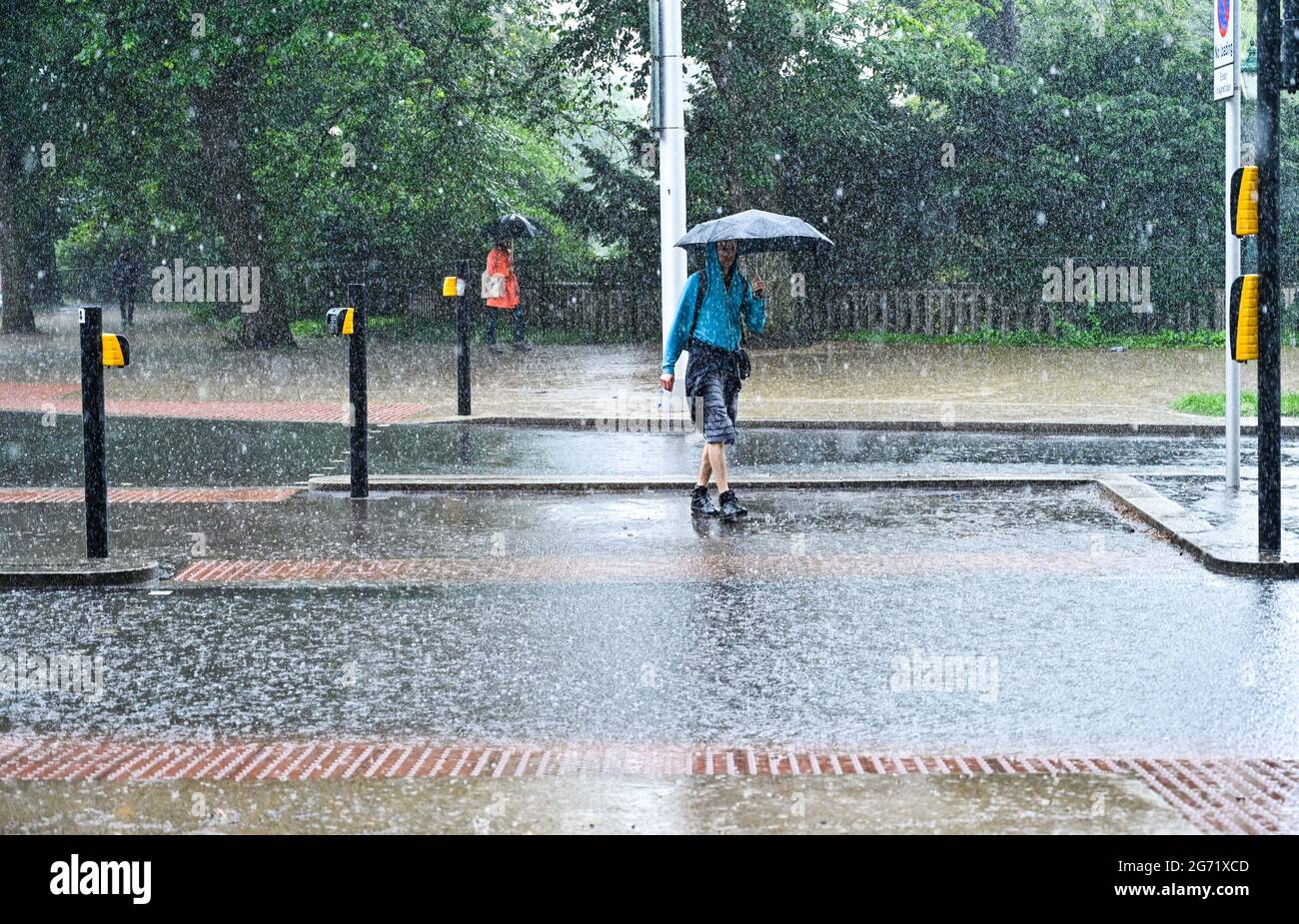 Brighton, Großbritannien. Juli 2021. - Fußgänger verhandeln über Sturzfluten im Stadtzentrum von Brighton, während heute starker Regen über den Südosten fegt : Credit Simon Dack / Alamy Live News Stockfoto