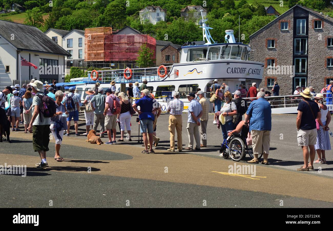 Eine Schlange von Leuten, die auf Dartmouth Riverboats 'Cardiff Castle' in Totnes warten. Viele tragen Gesichtsmasken während der Coronavirus-Pandemie. Stockfoto