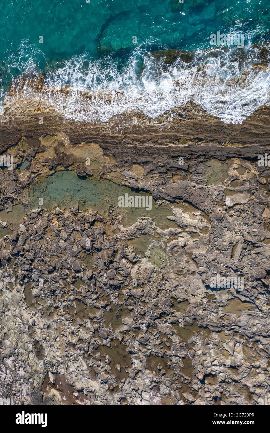 Gezeitenbecken bei Ebbe. Felsige Küste mit dramatischer Textur, vertikaler Blick von oben Stockfoto