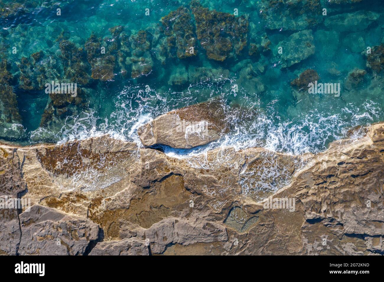 Meereswellen brechen an felsiger Küste, natürlicher Hintergrund aus der Luft Stockfoto