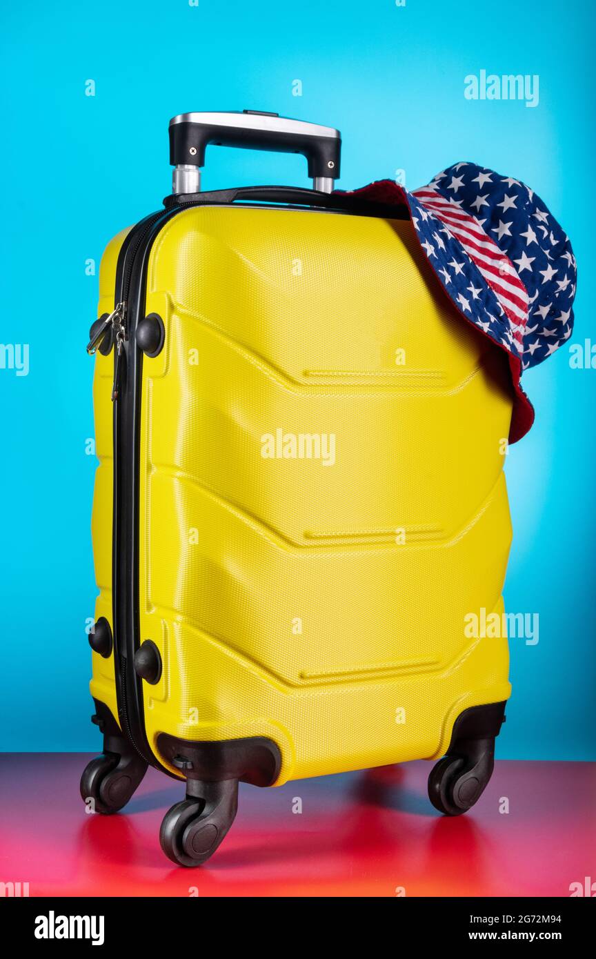 Gepäckkoffer und panama. Koffer und amerikanische Flagge. Tasche und Kopfstück mit der amerikanischen Flagge. Vertikaler Rahmen. Stockfoto