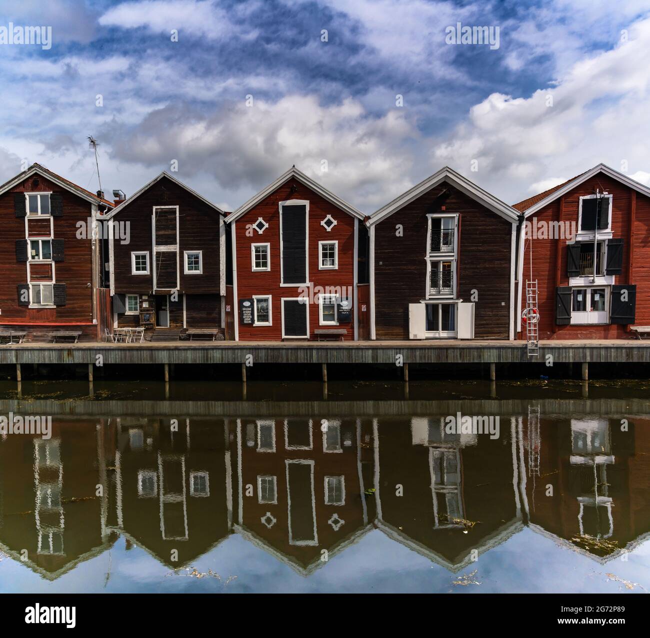 Hudiksvall, Schweden - 7. Juli 2021: Rote und braune Holzlager entlang der Uferpromenade in Hudiksvall Stockfoto
