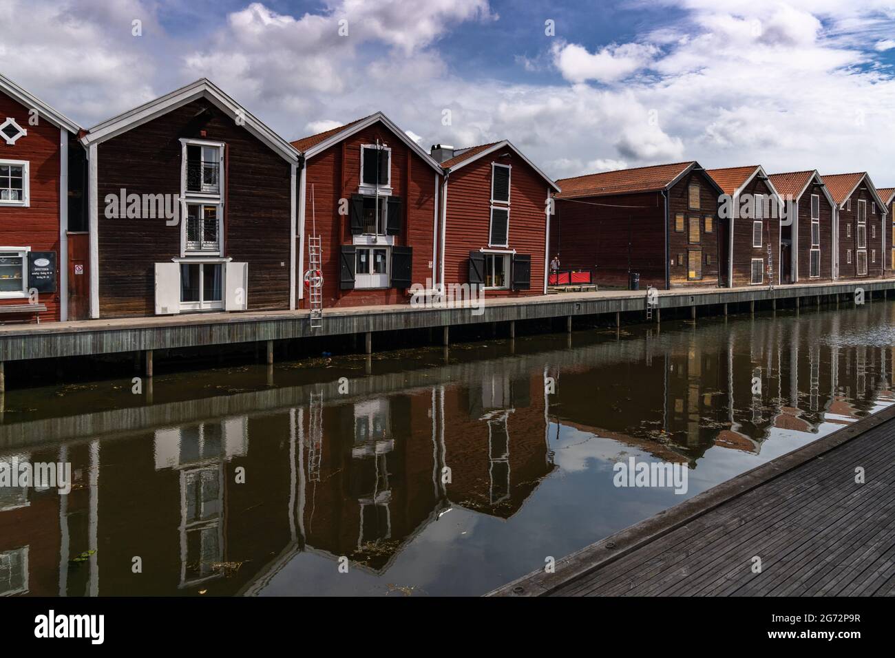 Hudiksvall, Schweden - 7. Juli 2021: Rote und braune Holzlager entlang der Uferpromenade in Hudiksvall Stockfoto