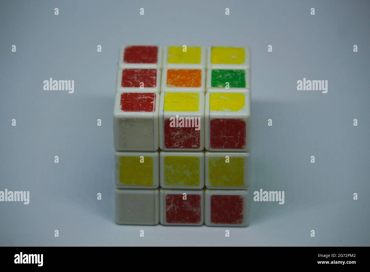 Ein alter zufälliger Rubik's Cube mit weißem Hintergrund Stockfoto
