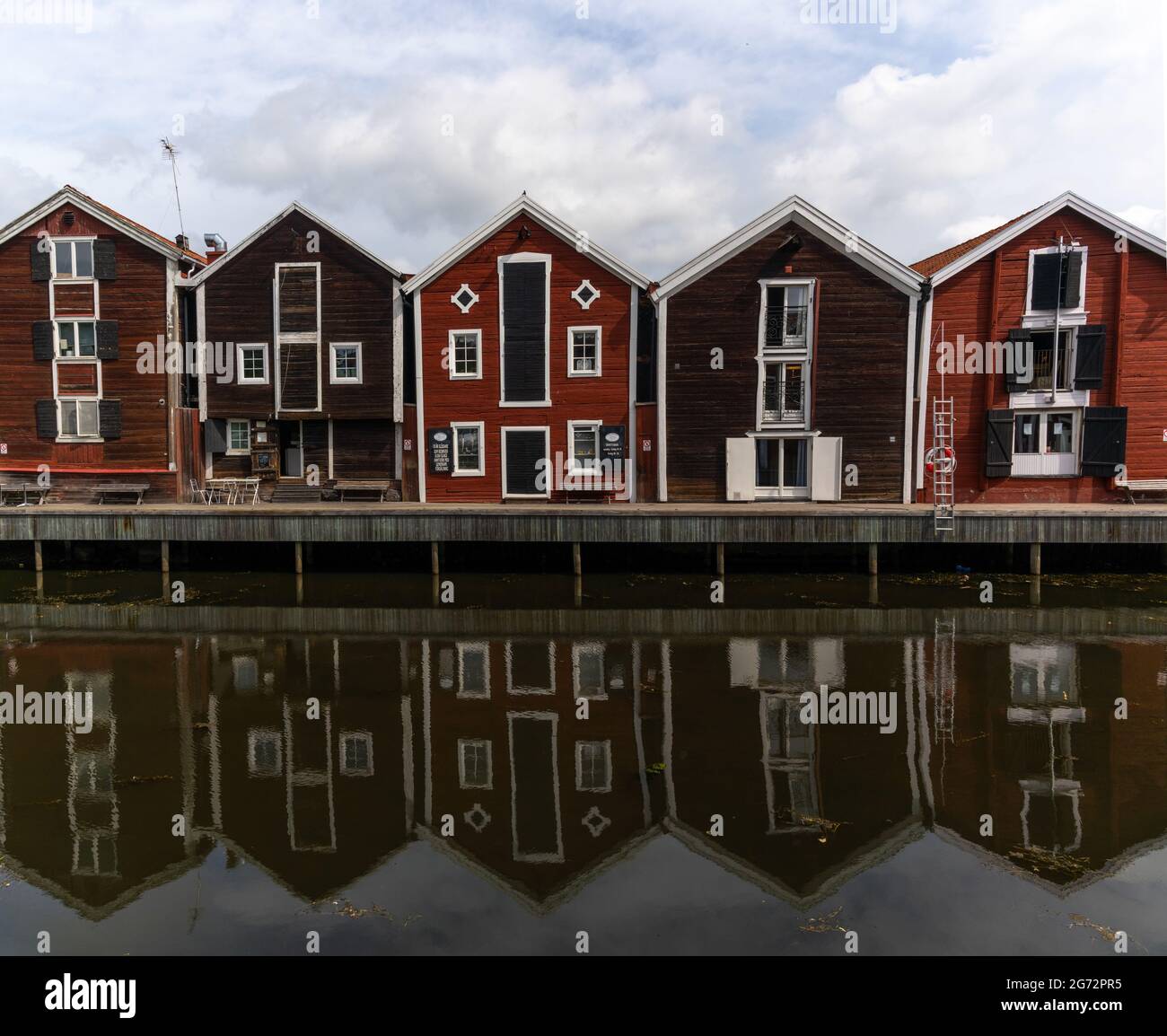 Hudiksvall, Schweden - 7. Juli 2021: Rote und braune Holzlager entlang der Uferpromenade in Hudiksvall Stockfoto