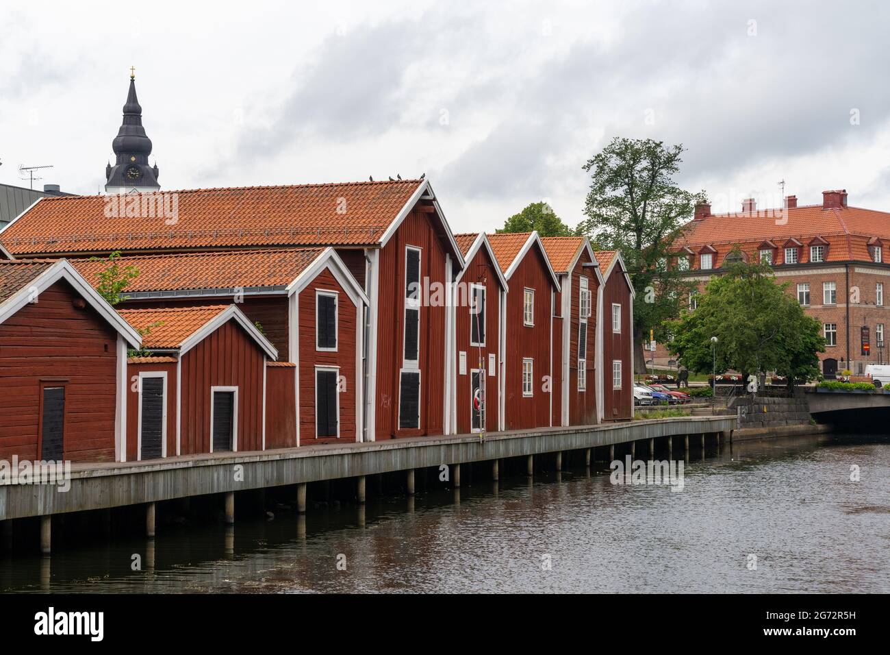 Hudiksvall, Schweden - 7. Juli 2021: Bunte Holzgebäude säumen den Kanal in der Innenstadt von Hudiskvall Stockfoto