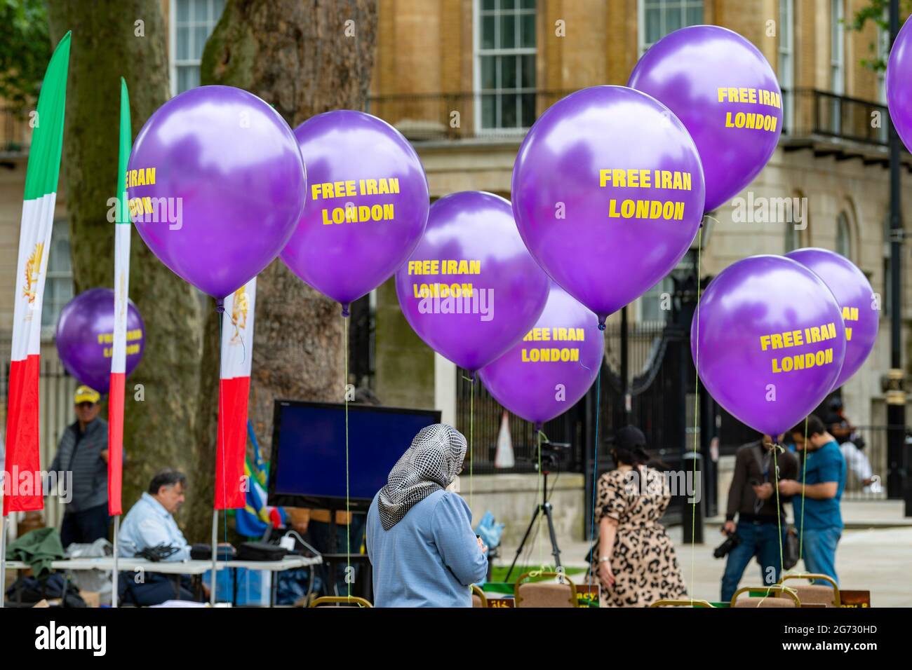 London, Großbritannien. Juli 2021. Aktivisten stehen unter Ballons mit dem Slogan Free Iran London vor dem jährlichen Free Iran World Summit, der zur Unterstützung der iranischen Volksmudschahedin Maryam Rajavi live übertragen wurde. (Foto von Dave Rushen/SOPA Images/Sipa USA) Quelle: SIPA USA/Alamy Live News Stockfoto
