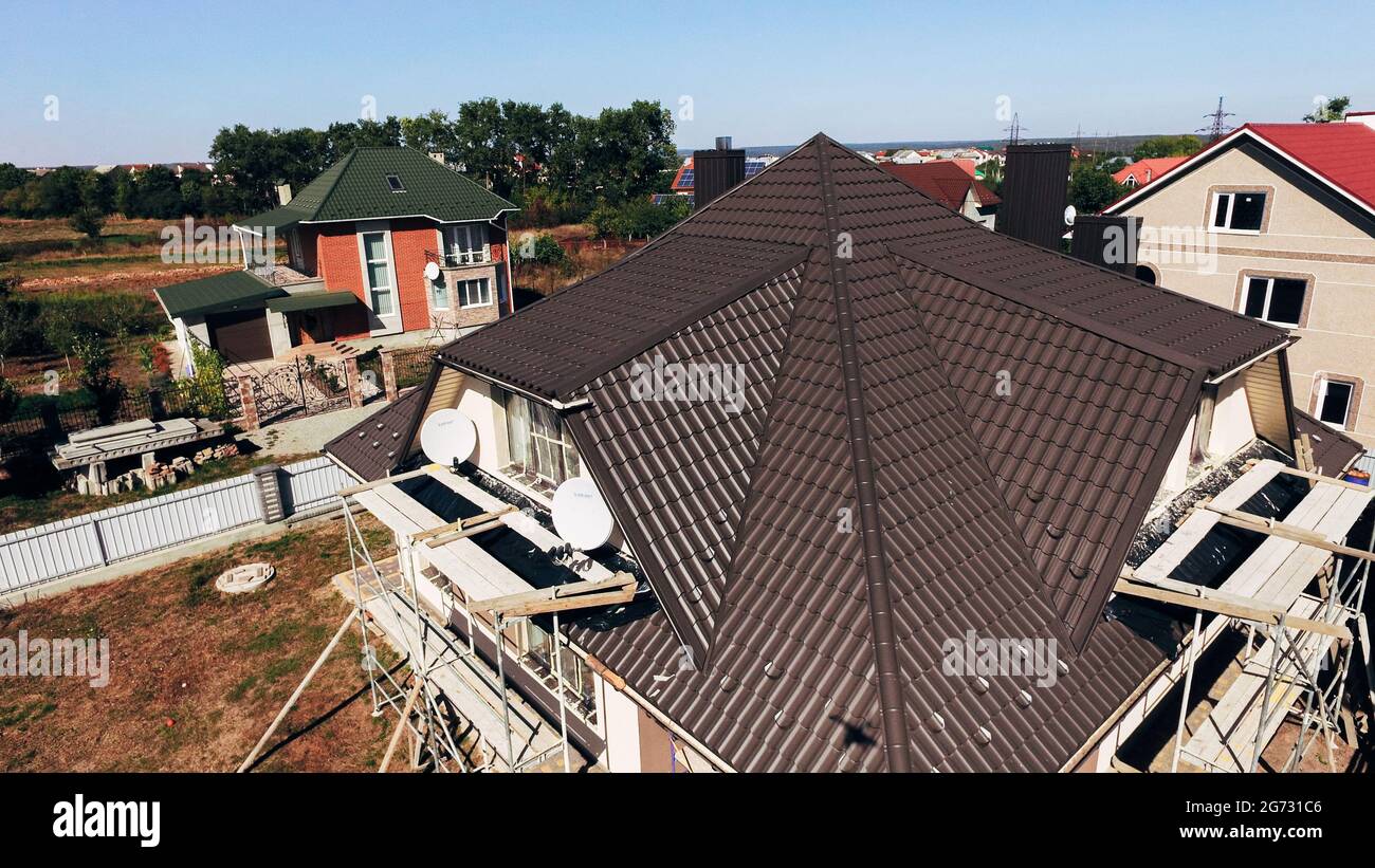 Luftaufnahme des roten Daches eines neuen Hauses in einem kleinen Dorf. Gefliestes Dach Stockfoto