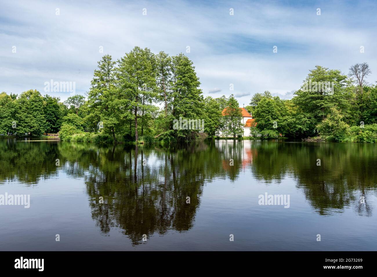 Schöne Aussicht auf Teich in Zwierzyniec, Roztocze, Polen. Park und berühmte St. John's of Nepomuk Kirche auf der Insel im Hintergrund. Stockfoto