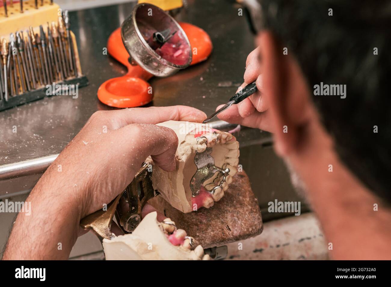 Zahntechniker repariert eine Zahnprothese Stockfoto