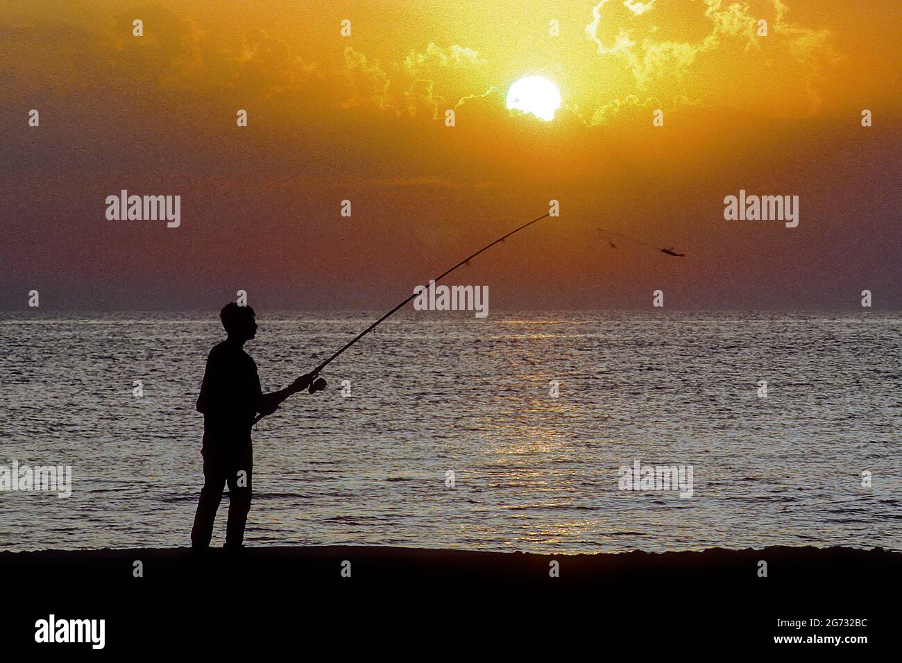 Ein Mann, der bei Sonnenaufgang am Cape Cod National Seashore angeln wird Stockfoto