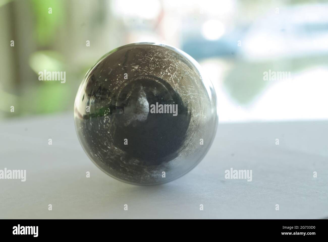 Planet Form Makro schmutzige Glühbirne Nahaufnahme, runde Glaskugel mit Staub und Kratzern im Inneren Stockfoto