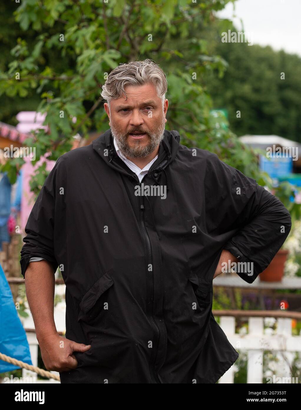 East Molesey, Surrey, Großbritannien. Juli 2021. Einer der Global Impact Gardens - der Fashion Footprint Garden. Designer Baz Grainger sprach heute mit Gärtnern über sein Design. Der Kies im Garten besteht aus weggeworfenen Knöpfen. Die beiden Fässer aus Cortenstahl erinnern an die Farbstoffbehälter, die beim Indigofärben verwendet werden. Quelle: Maureen McLean/Alamy Stockfoto