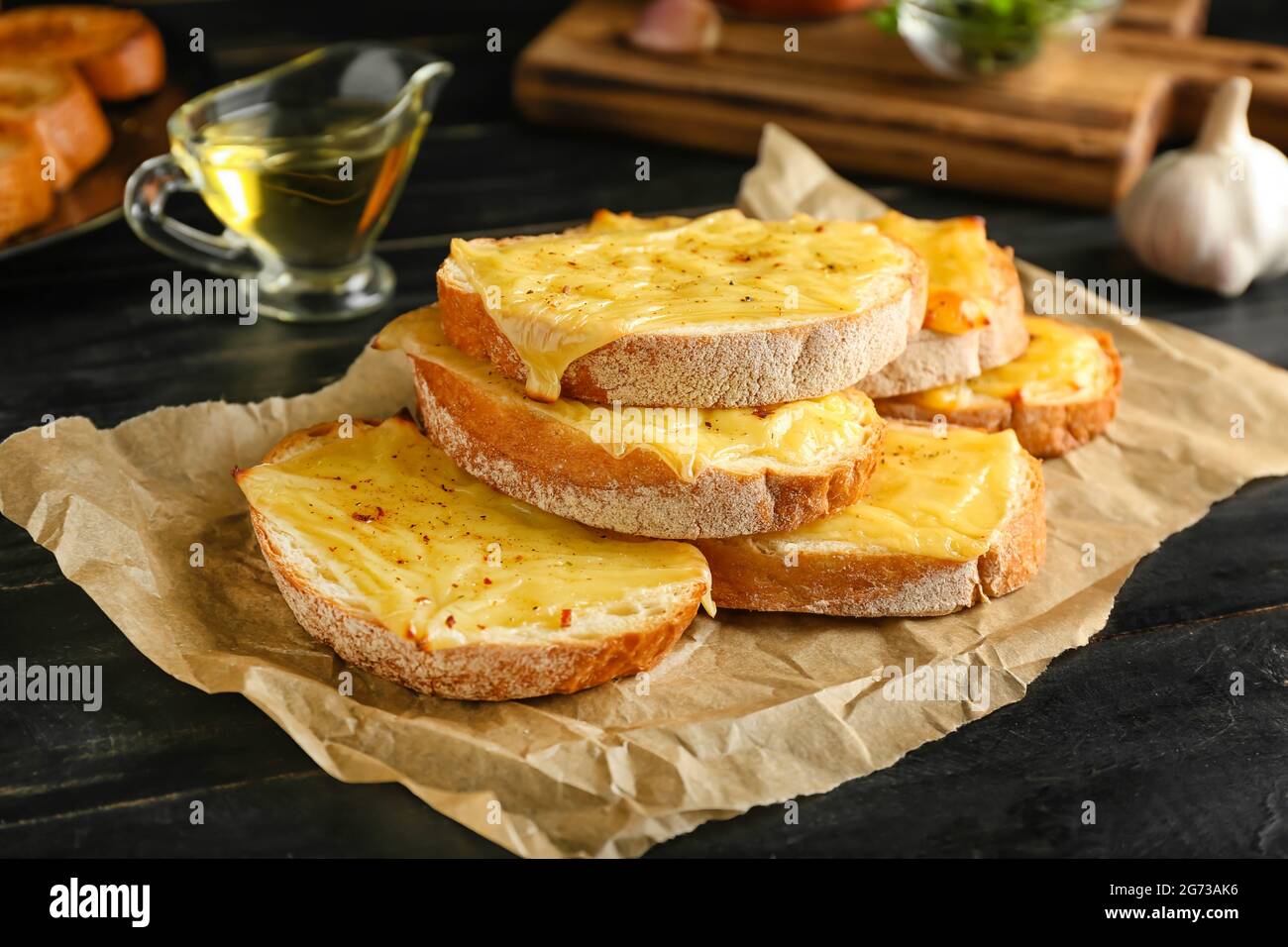 Leckere Toasts mit Käse auf dunklem Holzhintergrund Stockfoto