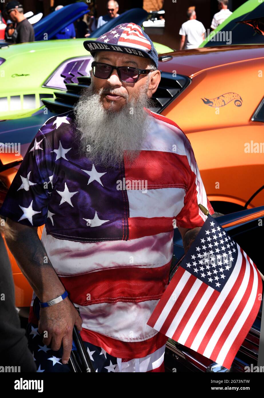 Ein Mann, der in den Farben und im Design der amerikanischen Flagge gekleidet ist, besucht eine Oldtimer-Show am 4. Juli in Santa Fe, New Mexico. Stockfoto