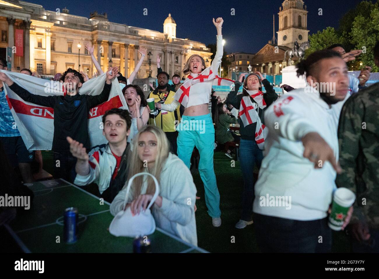 EURO 2020: England gegen Dänemark. England-Fans feiern auf dem Trafalgar Square, als England im Halbfinale 2-1 gewinnt, in zusätzlicher Zeit gegen Dänemark. VEREINIGTES KÖNIGREICH. Stockfoto