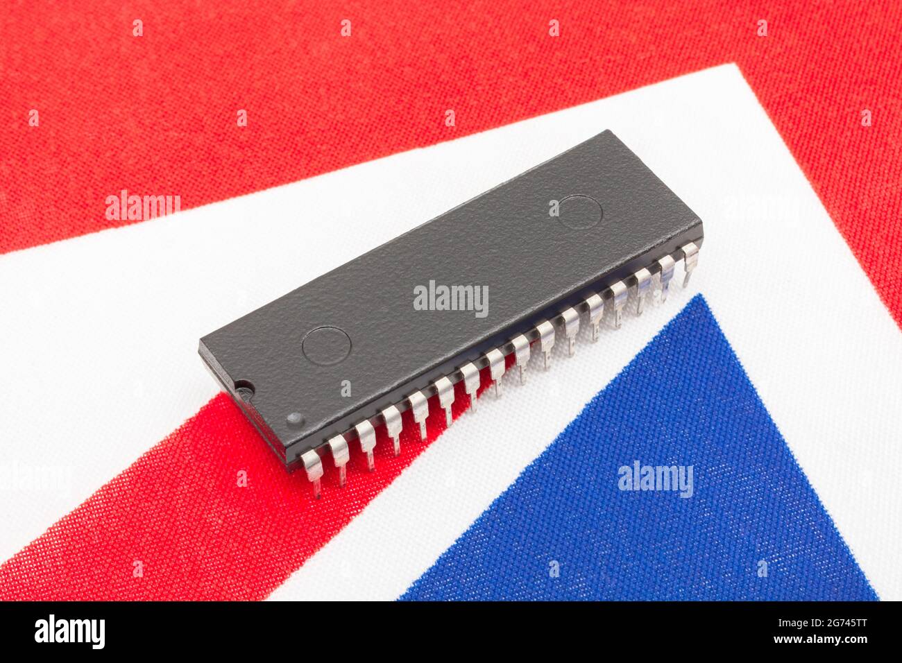 Nahaufnahme des integrierten Schaltkreises/EPROM-Chips auf der kleinen UK Union Jack-Flagge. Bei Halbleitermangel in Großbritannien, Abhängigkeit von britischen Chips, Start-ups von britischen Chips. Stockfoto