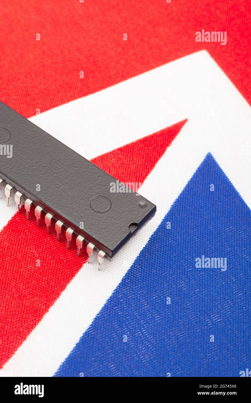 Nahaufnahme des integrierten Schaltkreises/EPROM-Chips auf der kleinen UK Union Jack-Flagge. Bei Halbleitermangel in Großbritannien, Abhängigkeit von britischen Chips, Start-ups von britischen Chips. Stockfoto