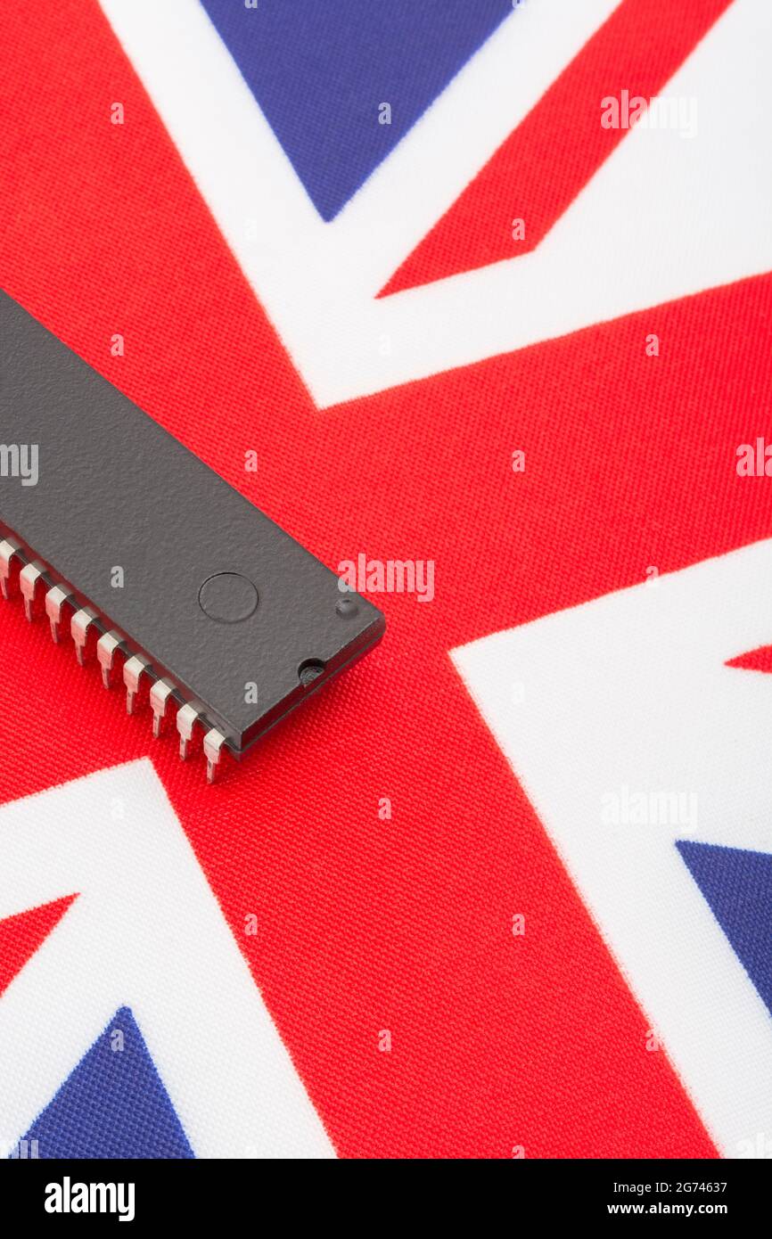 Nahaufnahme des integrierten Schaltkreises/EPROM-Chips auf der kleinen UK Union Jack-Flagge. Bei Halbleitermangel in Großbritannien, Abhängigkeit von britischen Chips, Start-ups von britischen Chips. Stockfoto