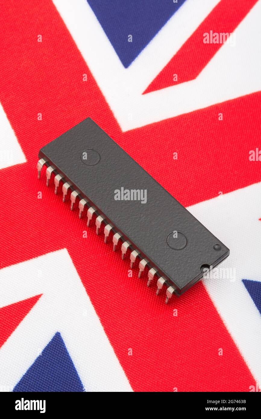 Nahaufnahme des integrierten Schaltkreises/EPROM-Chips auf der kleinen UK Union Jack-Flagge. Bei Halbleitermangel in Großbritannien, Abhängigkeit von britischen Chips, Start-ups von britischen Chips. Stockfoto