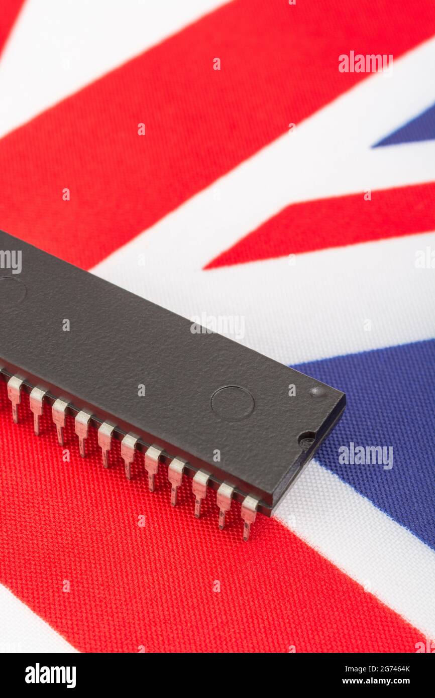 Nahaufnahme des integrierten Schaltkreises/EPROM-Chips auf der kleinen UK Union Jack-Flagge. Bei Halbleitermangel in Großbritannien, Abhängigkeit von britischen Chips, Start-ups von britischen Chips. Stockfoto