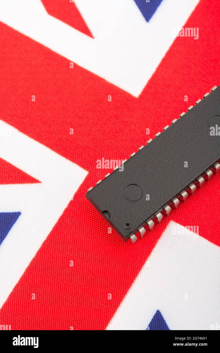 Nahaufnahme des integrierten Schaltkreises/EPROM-Chips auf der kleinen UK Union Jack-Flagge. Bei Halbleitermangel in Großbritannien, Abhängigkeit von britischen Chips, Start-ups von britischen Chips. Stockfoto