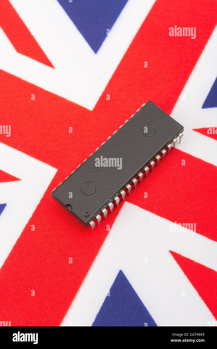 Nahaufnahme des integrierten Schaltkreises/EPROM-Chips auf der kleinen UK Union Jack-Flagge. Bei Halbleitermangel in Großbritannien, Abhängigkeit von britischen Chips, Start-ups von britischen Chips. Stockfoto